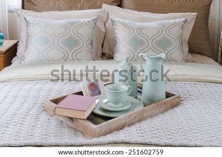 wood tray of tea cup set and book on bed in bedroom