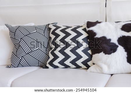black and white pillows on white sofa in living room at home