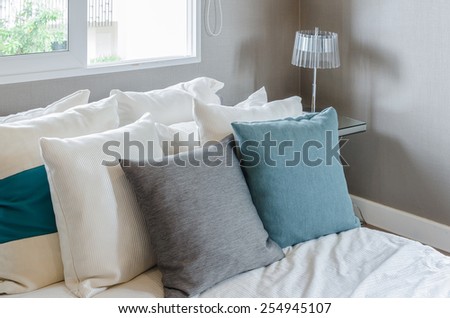 grey and green pillow on white bed in modern bedroom at home
