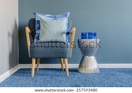 wooden chair with blue color pillow on carpet in living room