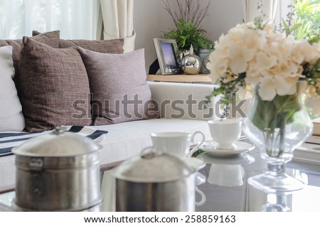 white sofa with brown pillows in living room and blur foreground effect