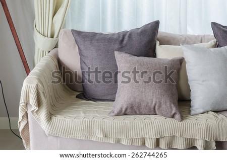 pillows and blanket on earth tone sofa in living room