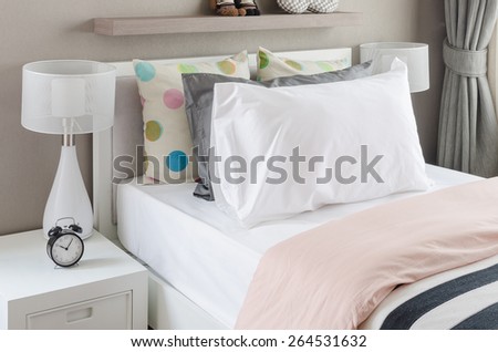 kid\'s bedroom with white pillows and lamp on modern bed at home