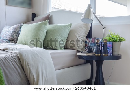 green pillows on bed with round wooden table at home