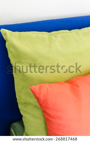 row of colorful pillows on bed at home