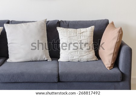 three of pillows on dark blue sofa in modern living room