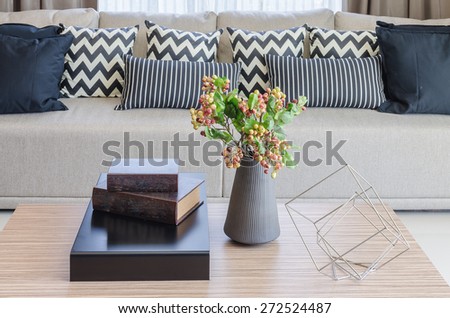vase of flower with books on wooden table in living room at home