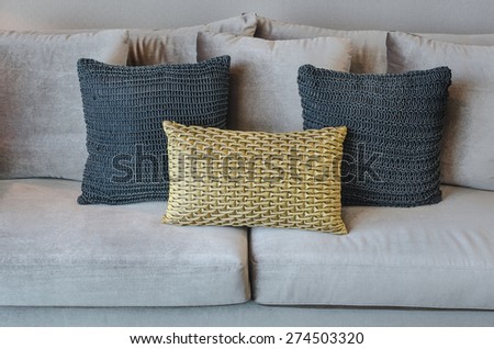 gold and black color pillows on grey sofa in living room