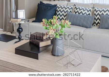 vase of flower with books on wooden table in living room at home