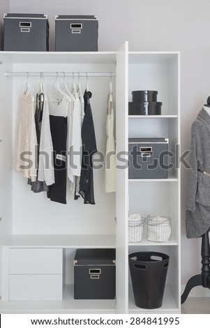 black and white clothes hanging in white wardrobe