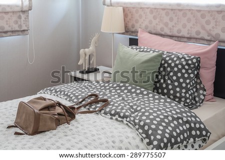 green pillow on kid's bedroom with brown bag at home