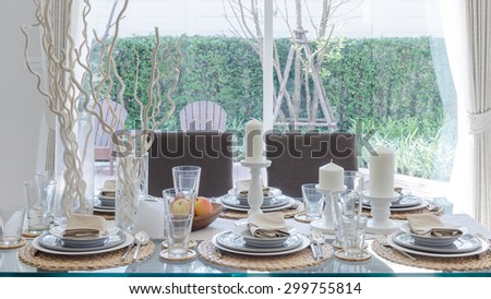 table set on glass dinning table in dinning room with garden view