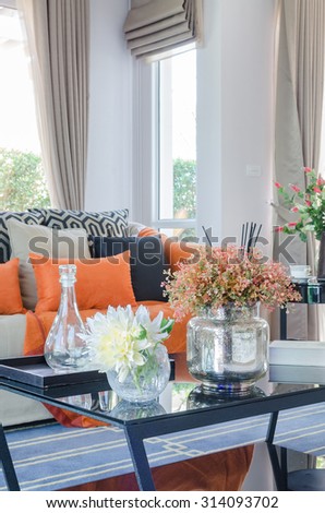 orange pillows and blanket on modern sofa in living room at home