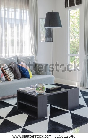 colorful pillows on modern grey sofa in living room with black table