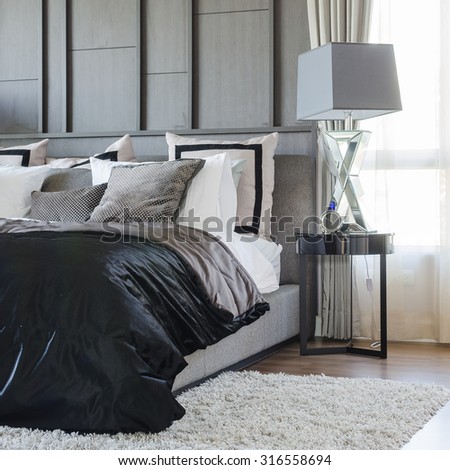 modern bedroom design in black and white color scheme with modern lamp on side table