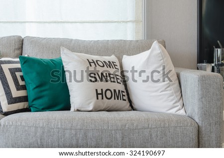 modern grey sofa with black and white and green pillows in living room