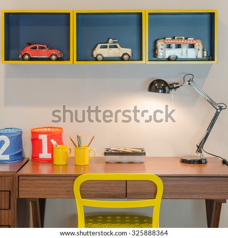 yellow chair and wooden desk with modern black lamp in kid\'s bedroom