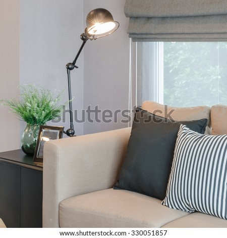 modern living room with black lamp on table side and glass vase of plant