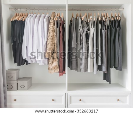 white wardrobe with clothes hanging on rail