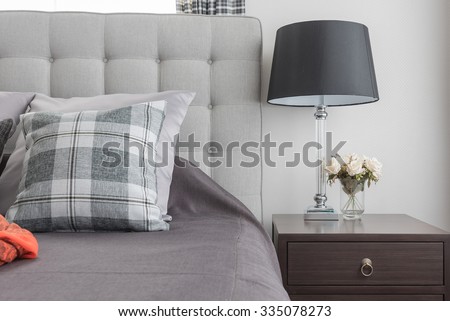 classic lamp style with vase of flower on wooden bedside table in classic bedroom