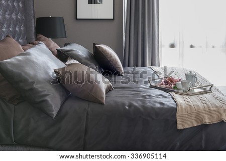 luxury bed with pillows and tray of tea set on blanket in bedroom