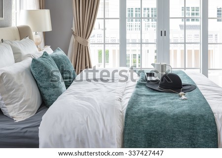 black hat on green blanket on bed in luxury bedroom at home