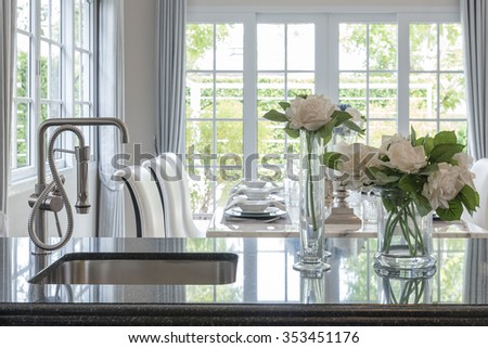 glass vase of flower on black granite counter with modern sink and faucet in classic pantry room