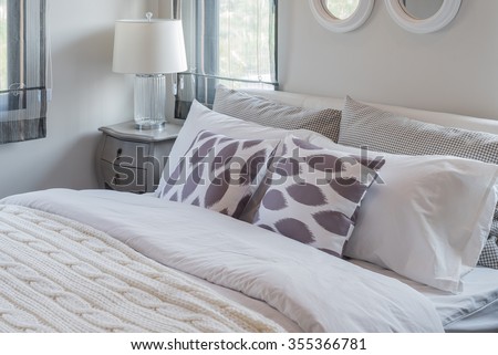 modern white bedroom with white bed and white lamp on wooden table side