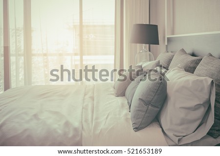 pillows on bed and luxury black lamp style on wooden table side in bedroom design, vintage process style