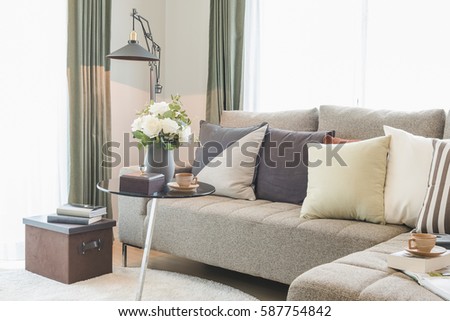 vase of flower on round glass table with set of sofa in modern living room interior design concept