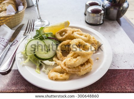 A plate of fried calamari (squid rings) with salad garnish at a seafood restaurant in Brighton, East Sussex, UK