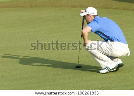KUALA LUMPUR - APRIL 15: Martin Kaymer of Germany lines up the putt on the 17th green during 3rd round match of Maybank Malaysian Open 2012 at Kuala Lumpur Golf & Country Club on April 15, 2012