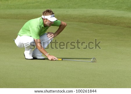 KUALA LUMPUR - APRIL 15: Jbe Kruger of South Africa lines up his putt on the 17th green during 3rd round of Maybank Malaysian Open 2012 at Kuala Lumpur Golf & Country Club on April 15, 2012