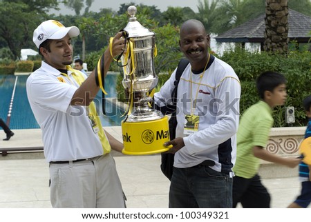 KUALA LUMPUR - APRIL 15: SS Kanessan photographer of The Star, a local new agency posed with the trophy of Maybank Malaysian Open 2012 at Kuala Lumpur Golf & Country Club on April 15, 2012