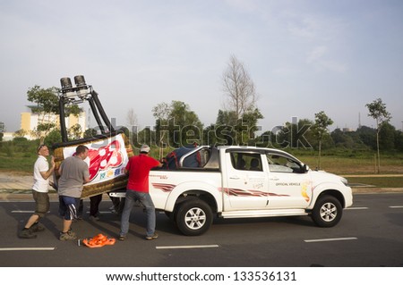 KUALA LUMPUR - MARCH 30: Sven Grenzner(C) insert basket balloon into 4-wheel drive car after landed in the middle of the road at Putrajaya, Malaysia on March 30, 2013.