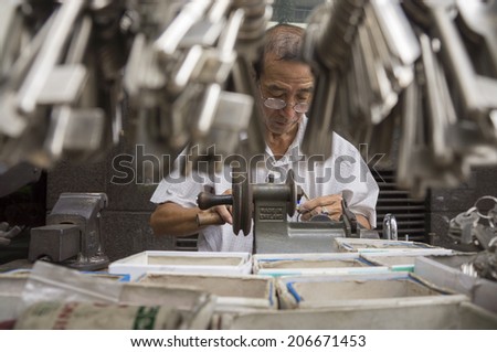 KUALA LUMPUR JULY 22 Sunny Lim 63 making a duplicate of key at his stall in Tun Tan Siew Sin street Kuala Lumpur Malaysia on July 22 2014 KUALA LUMPUR JULY 22 Sunny Lim 63 making a duplicate of key at his stall in Tun Tan Siew Sin street Kuala Lumpur Malaysia on July 22 2014