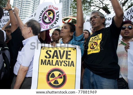 KUALA LUMPUR, MALAYSIA-MAY 20: Demonstrators holds poster during a protest against a proposed rare earth plant to be built in Gebeng, in front of Petronas Twin Towers in Kuala Lumpur May 20, 2011.