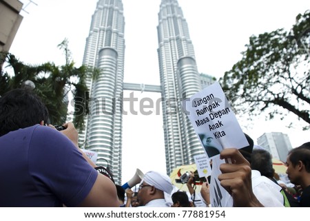 KUALA LUMPUR, MALAYSIA-MAY 20: An activist holds a placard during a protest against a proposed rare earth plant to be built in Gebeng, in front of Petronas Twin Towers in Kuala Lumpur May 20, 2011.