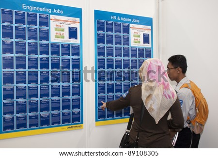 KUALA LUMPUR, MALAYSIA- NOVEMBER 19: A job seekers checking the list of job vacancy during B.N Job Fairs 2011 in Kuala Lumpur, Malaysia on November 19, 2011.