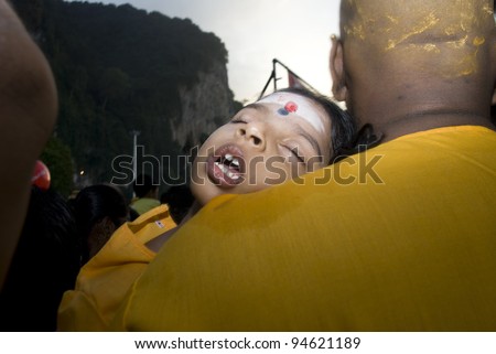 BATU CAVE, MALAYSIA-FEB 7:  An unidentified  children devotees sleep on her father shoulder during the Thaipusam festival in Batu Caves, near Kuala Lumpur, Malaysia on February 7, 2012.