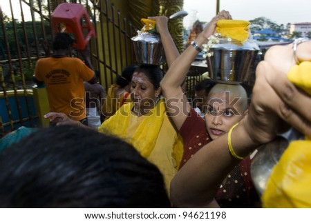 BATU CAVE, MALAYSIA-FEB 7:  Women devotees carrying milk pots to be presented to Lord Murugan during the Thaipusam festival in Batu Caves, near Kuala Lumpur, Malaysia on February 7, 2012.