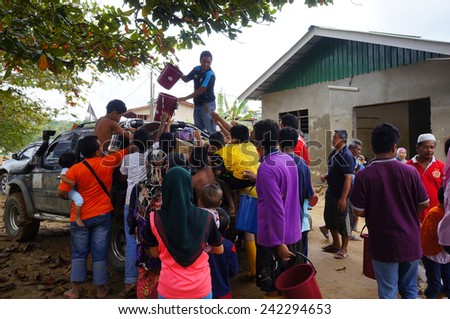 TANAH MERAH, KELANTAN - JANUARY 2: Flood victims receive food aid from NGO\'s in Kusial Baru village, Tanah Merah, Kelantan on January 2, 2015