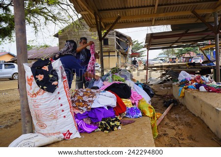 TANAH MERAH, KELANTAN - JANUARY 2: Flood victims choose clothing that is given by flood relief in Kusial Baru village, Tanah Merah, Kelantan on January 2, 2015