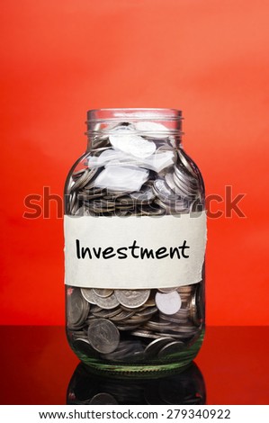 Investment label on glass jar with coins