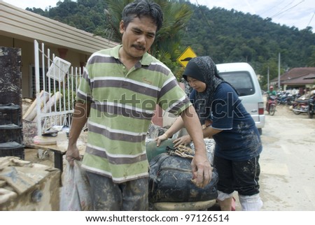 KUALA LUMPUR - MARCH 8: Flash flood victims clean up leftover garbage and mud brought by the floods in Ampang, near Kuala Lumpur, Malaysia on Mac 8, 2012