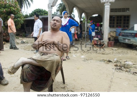KUALA LUMPUR - MARCH 8: A flood victims exhausted after doing the work of flood clean up trash in Ampang, near Kuala Lumpur, Malaysia on Mac 8, 2012
