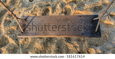 Wood swing isolated on sand background