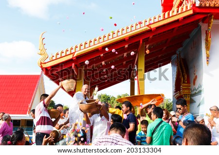 ROYONG , THAILAND - JULY 6 : Celebration of a new buddhist monk, The new monk is thrown the money toward the many people for charity. JULY 6, 2014 in Rayong , Thailand.