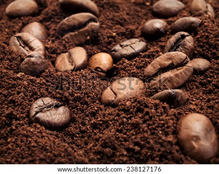 Large grains of black coffee scatterings of ground coffee is used as a background