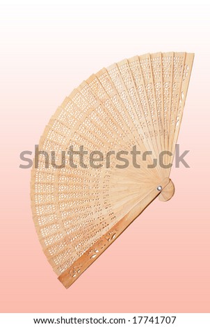 Handmade wooden fan on pink background.